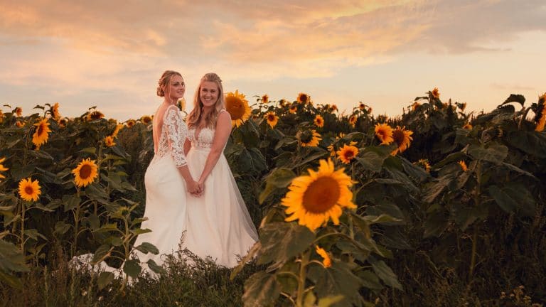 Beth and Em in a sunflower field at sunset